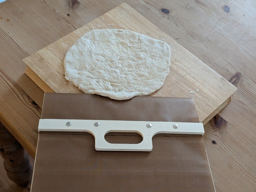 sliding pizza peel attempting to pick up raw dough