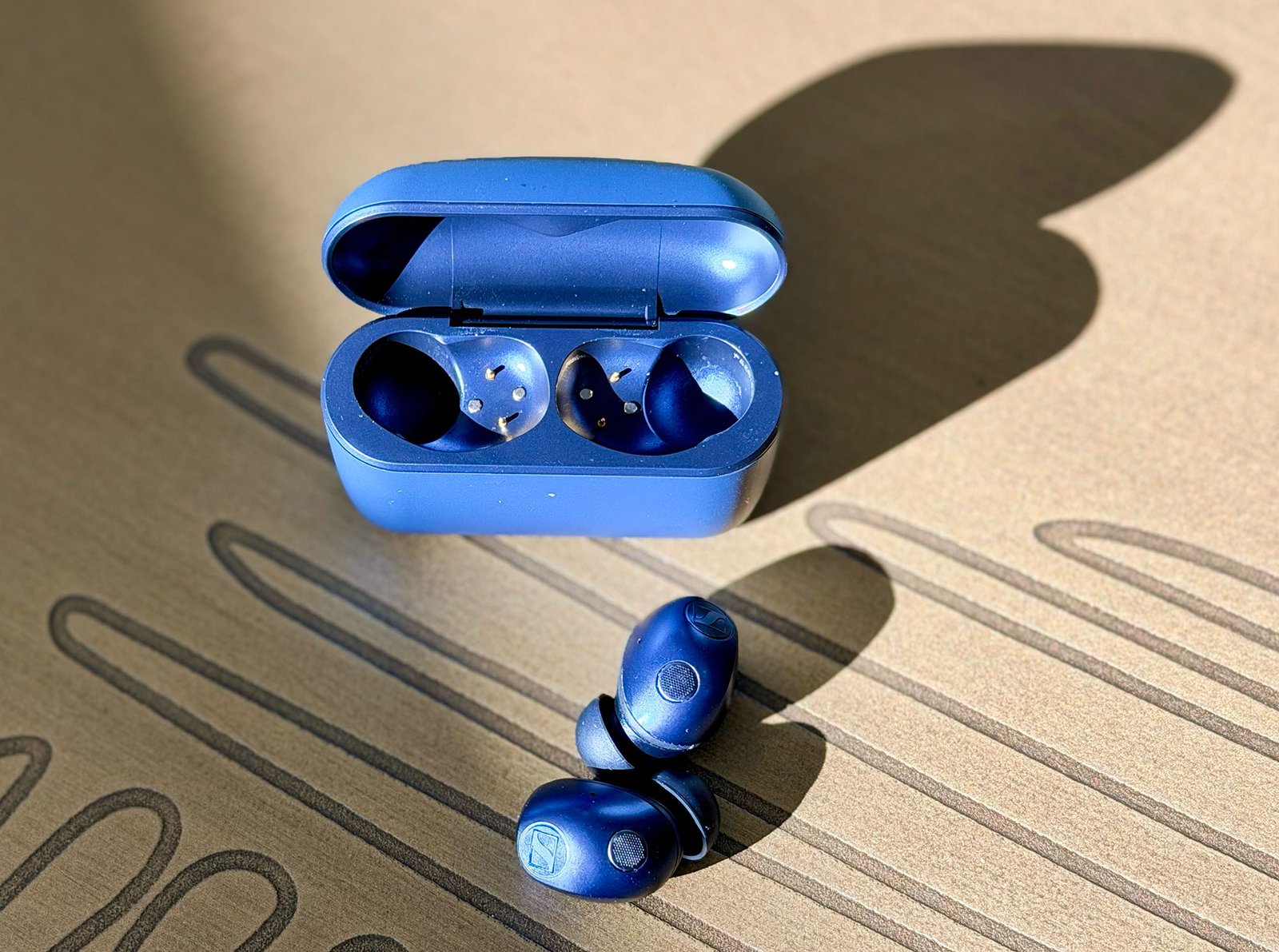 The Sennheiser MTW5 earbuds + case on a table
