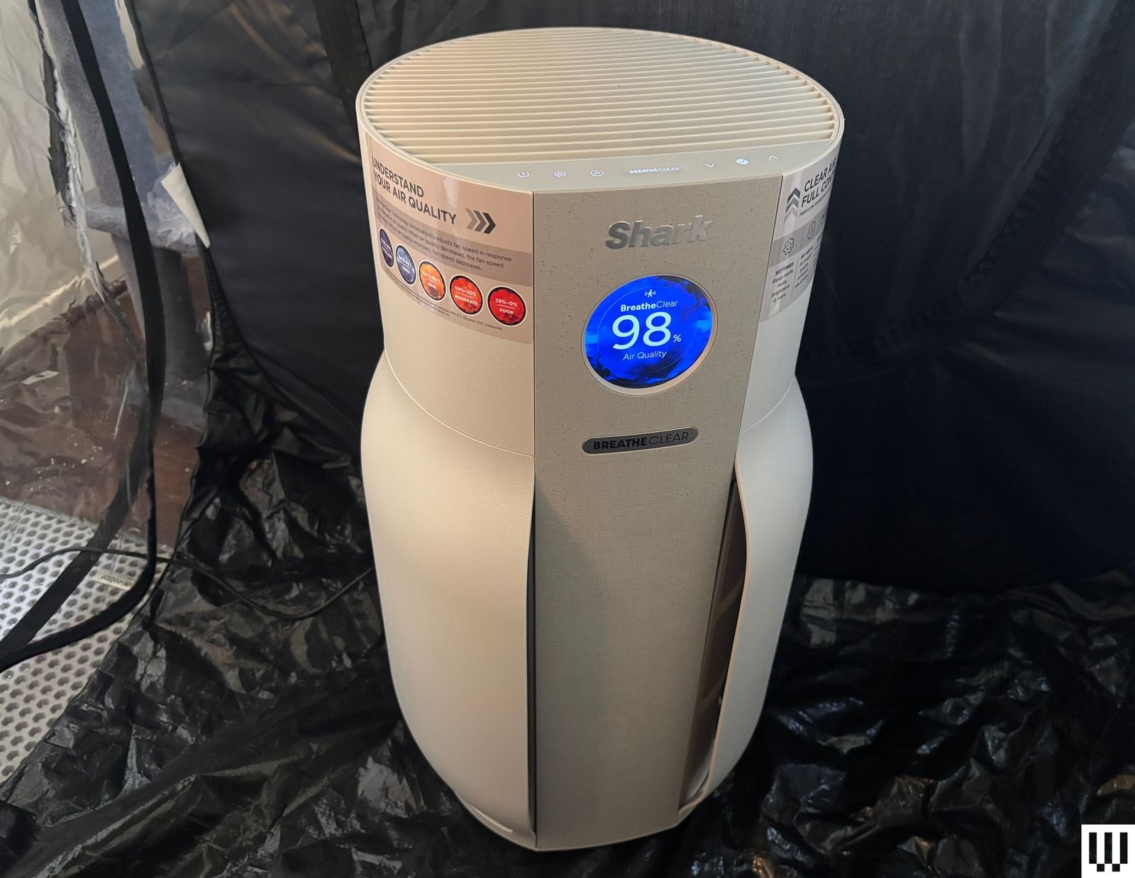 White cylindrical air purifier sits in black tent