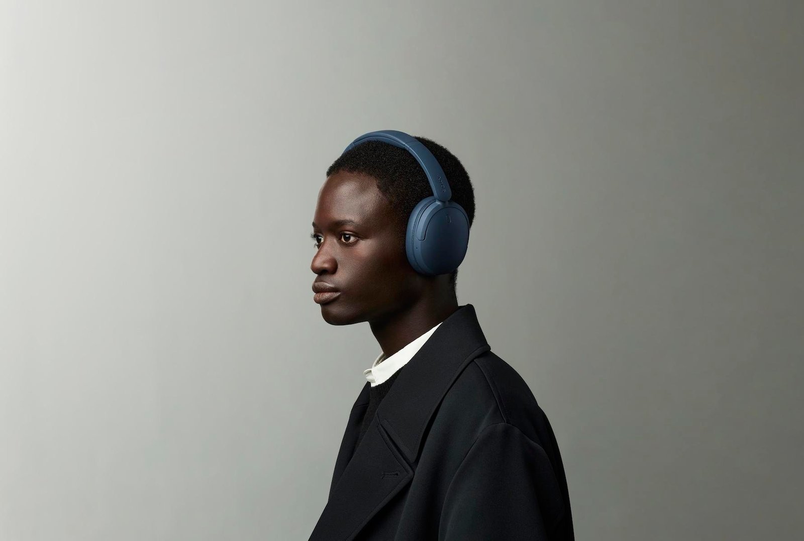 A person wearing the blue Sony WH-CH730N headphones.