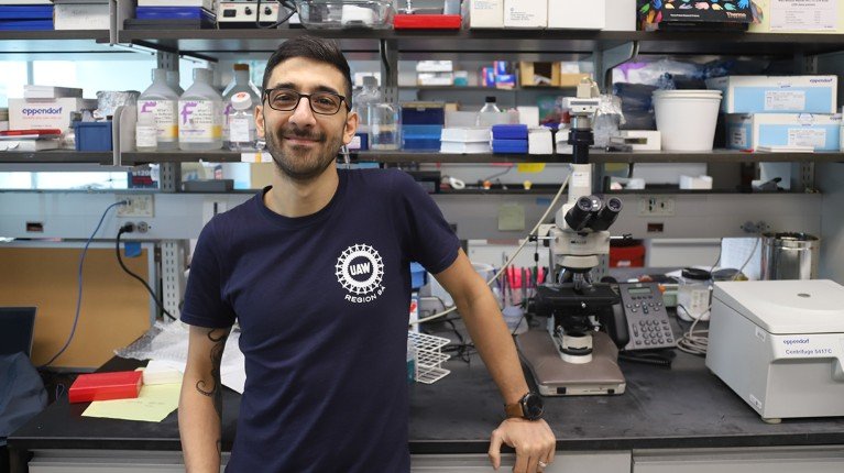 Portrait of Stefano Cataldi leaning against a workbench in a laboratory.