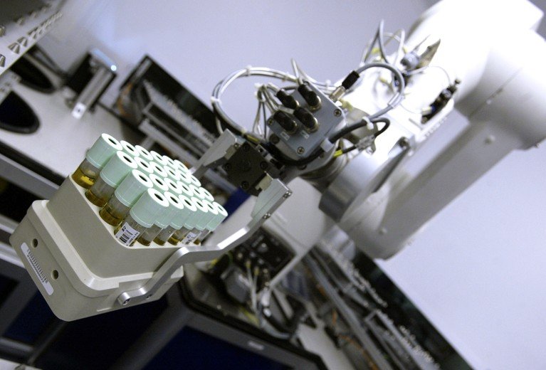A close-up view of blood samples being processed by a robotic arm at the UK Biobank laboratory.