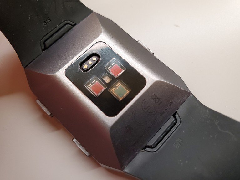 Close-up of the back of a smartwatch, on a plain background.