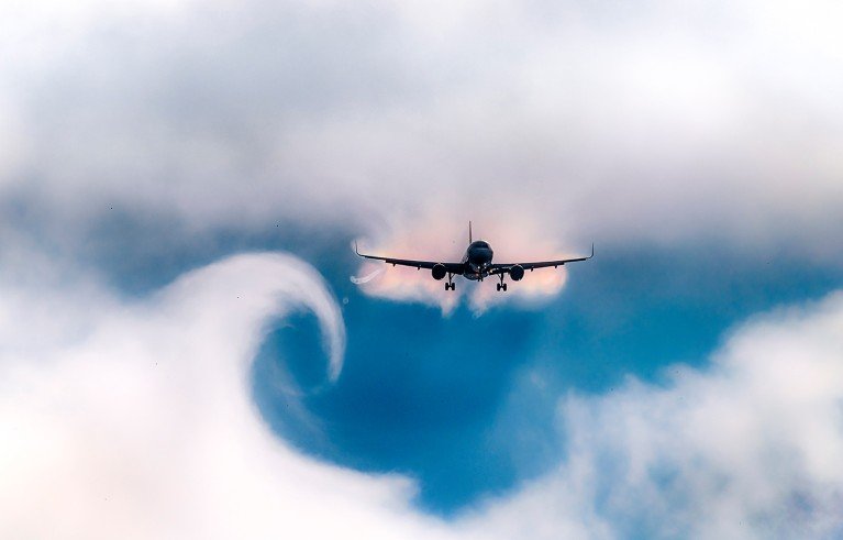 Cloud turbulence forming a vortex near an aircraft.