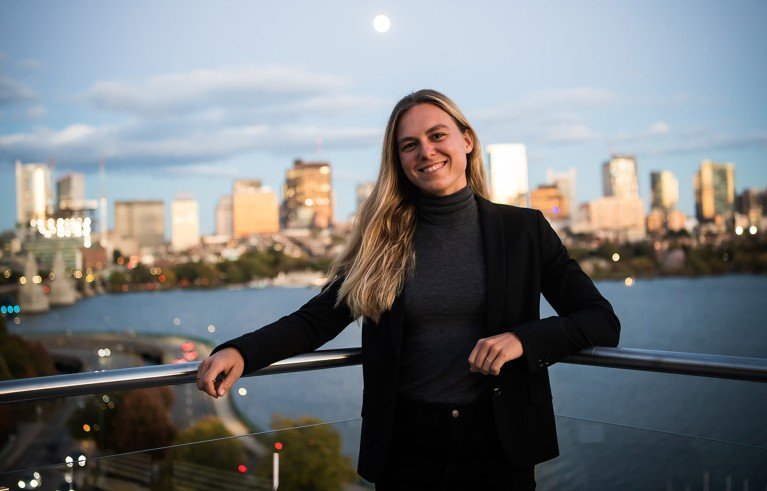 Portrait of Anna Pertl on a balcony overlooking a city skyline.
