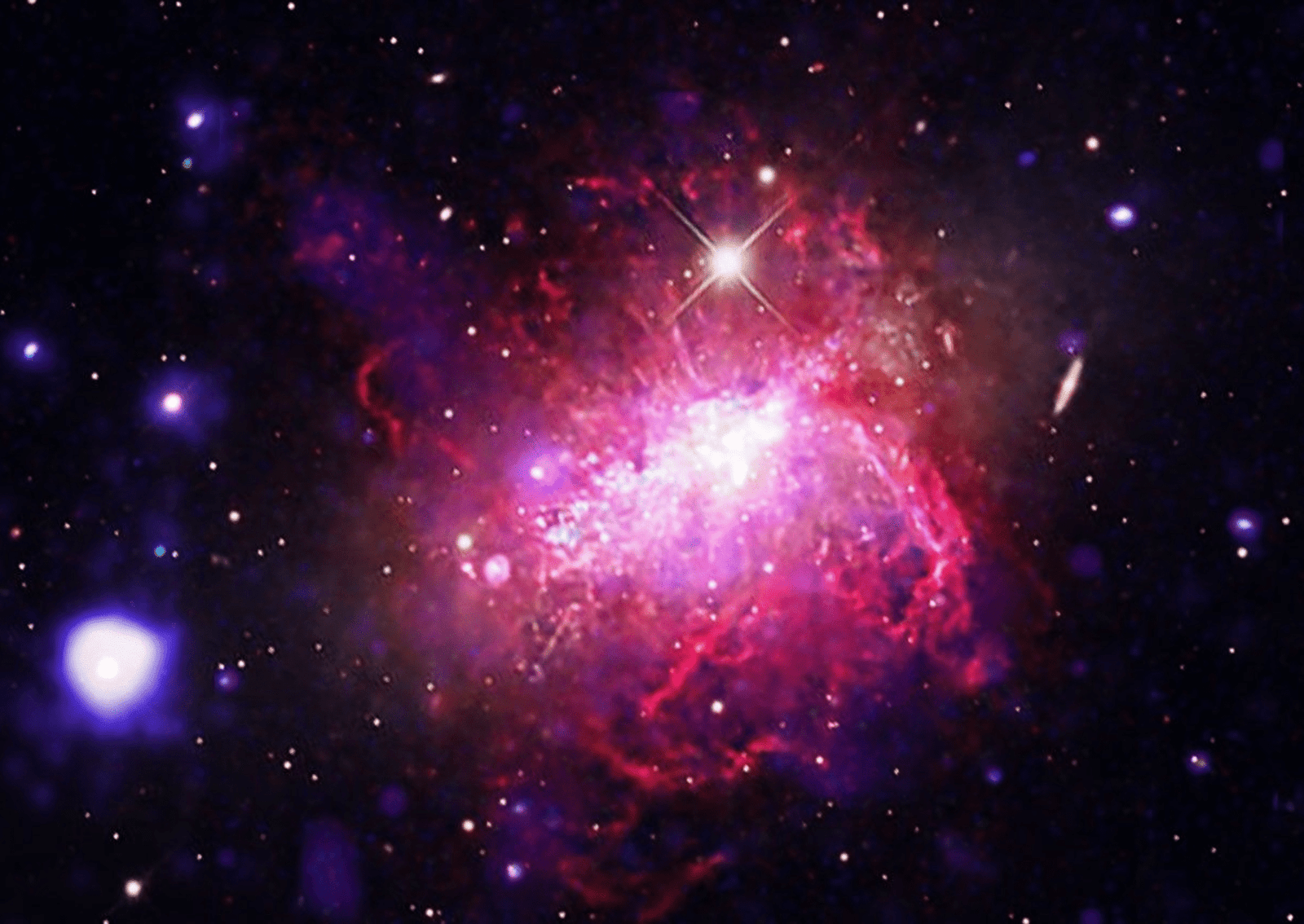 A compact dwarf irregular galaxy undergoing a violent, compact burst of star formation. Chandra and XMM-Newton observations (blue and purple) reveal massive bubbles of million-degree gas inflated by stellar winds, set against a backdrop of optical light (magenta, orange and white) imaged by Adam Block. Dwarf starburst galaxies can serve as local laboratories for studying the conditions of the early universe, where small, primitive galaxies formed stars at frantic rates. Image: X-ray: (XMM):ESA/XMM-Newton, (Chandra): NASA/CXC/SAO; Optical: Univ.of Arizona/Mt Lemmon SkyCenter/Adam Block/Josep Drudis; Image Processing: NASA?CXC/SAO/L. Frattare.