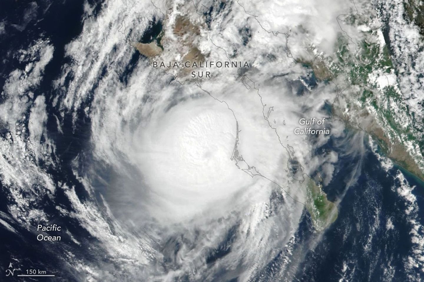 Hurricane Polo’s clouds spiral over the Pacific Ocean and the Baja California peninsula. The storm’s faint eye is just off the west coast of the peninsula.
