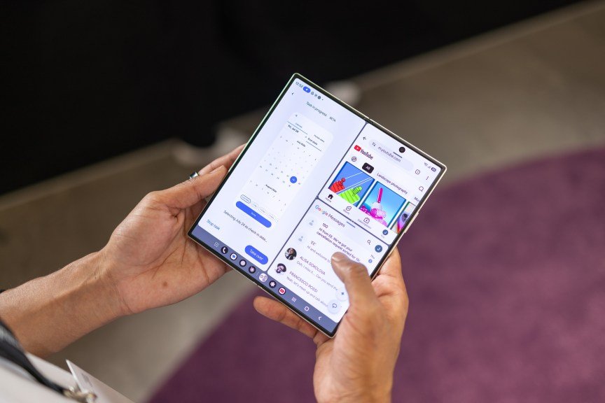 A foldable phone unfolded to show its large screen, with two apps running separately on the right and left halves.