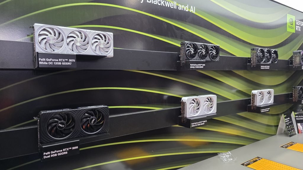 Six GPUs on a display wall, featuring various different types from 5070, to 5050, and available in both 3 and 2 fan options, as well as black or white.