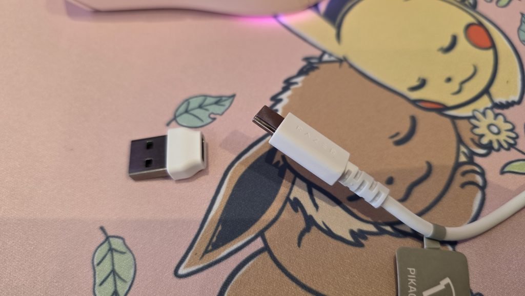 The end of the white headset cable, showing that on the end of the cable is USB-C, and next to it is a tiny USB-C to USB-A adatper.