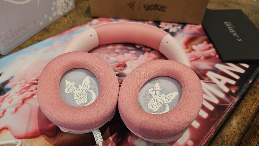 The inside photo of the earcups showing the white Slyveon looking out of each earcup with a smile.