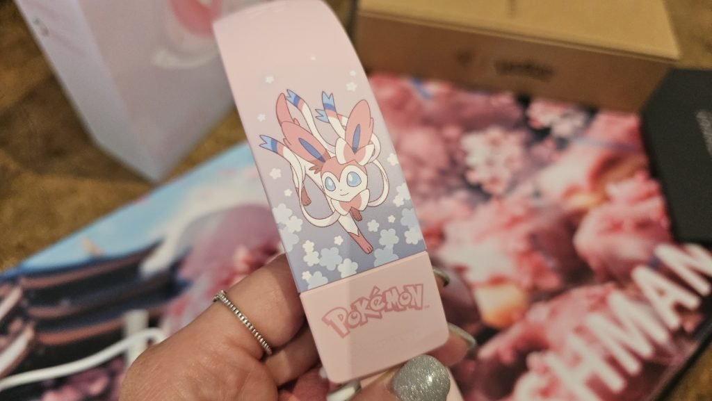Side shot of the headset showing Slyveon on the side of the band and a pink pokemon logo underneaht.