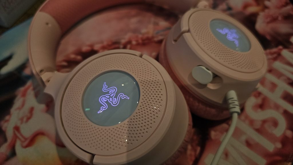 Photo of the outside of the earcups showing the pink Razer logo lit up.