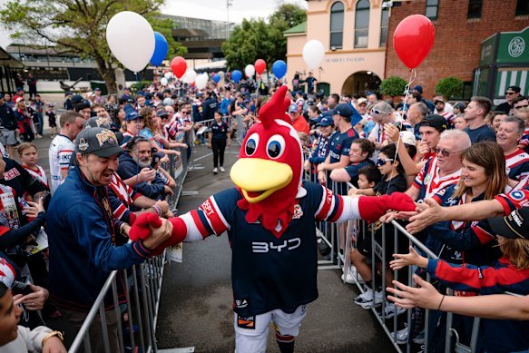 Club mascot Rocky the Rooster shakes hands with the flock.