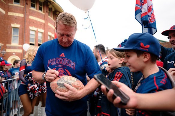 Sydney Roosters head coach Trent Robinson signs for fans.