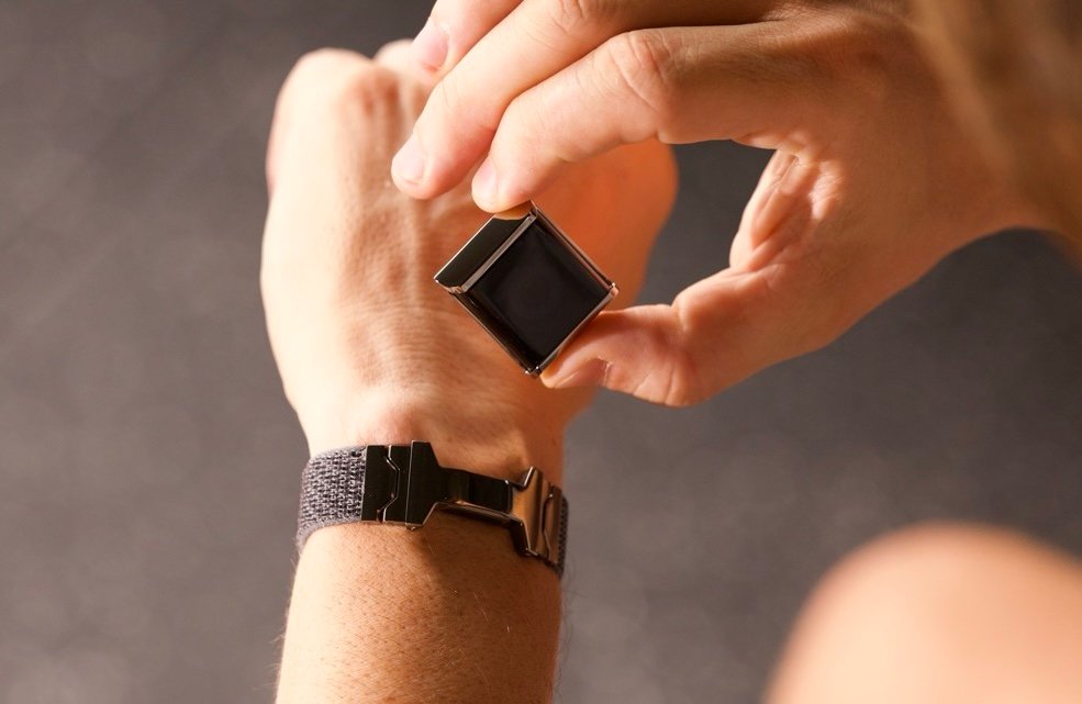 A hand putting the Halo hardware on the Alloop wearable wristband.
