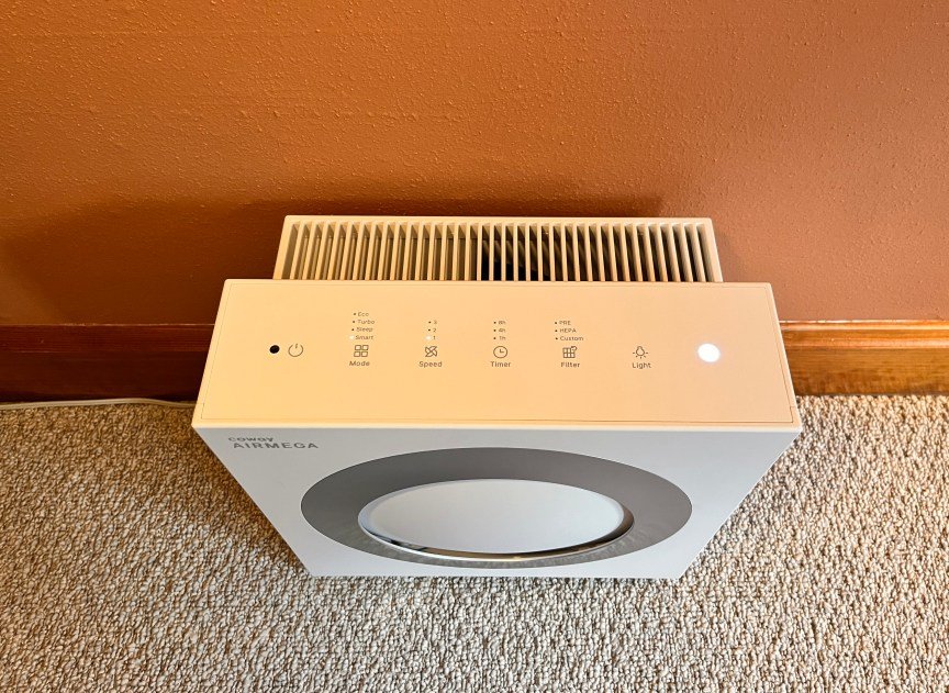 A white square Coway air purifier sitting on a floor