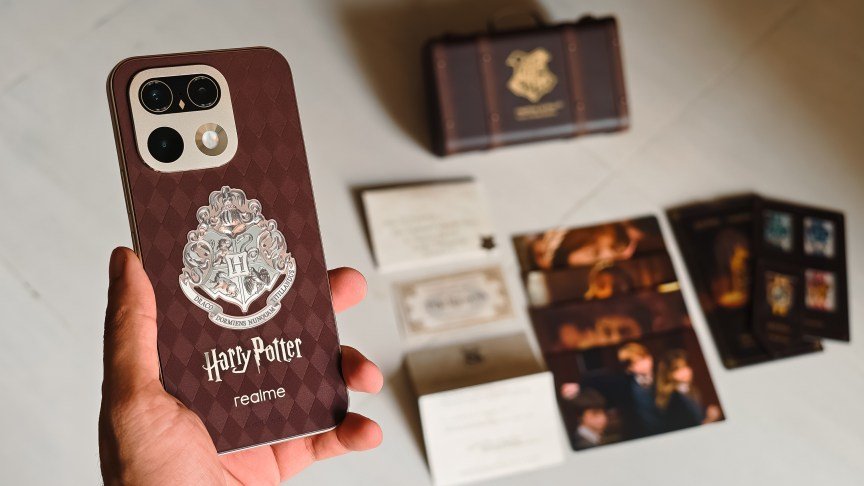 Prakhar Khanna holding the Realme 16 Pro 5G Harry Potter Edition phone with its goodies in the background.
