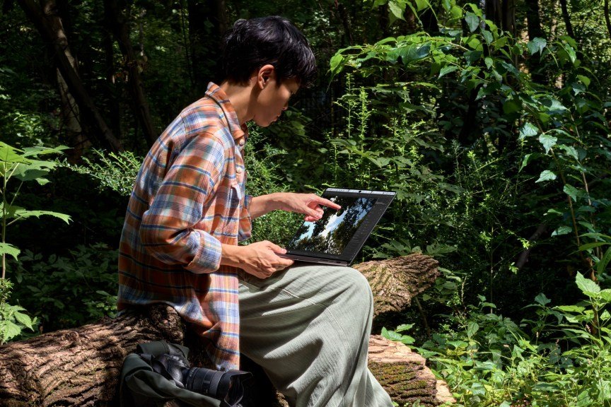A photo showing a man using the new MacBook Pro with PROLED XDR Display and Touch