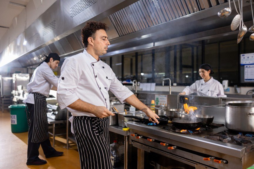 Chefs cooking in a restaurant kitchen. 