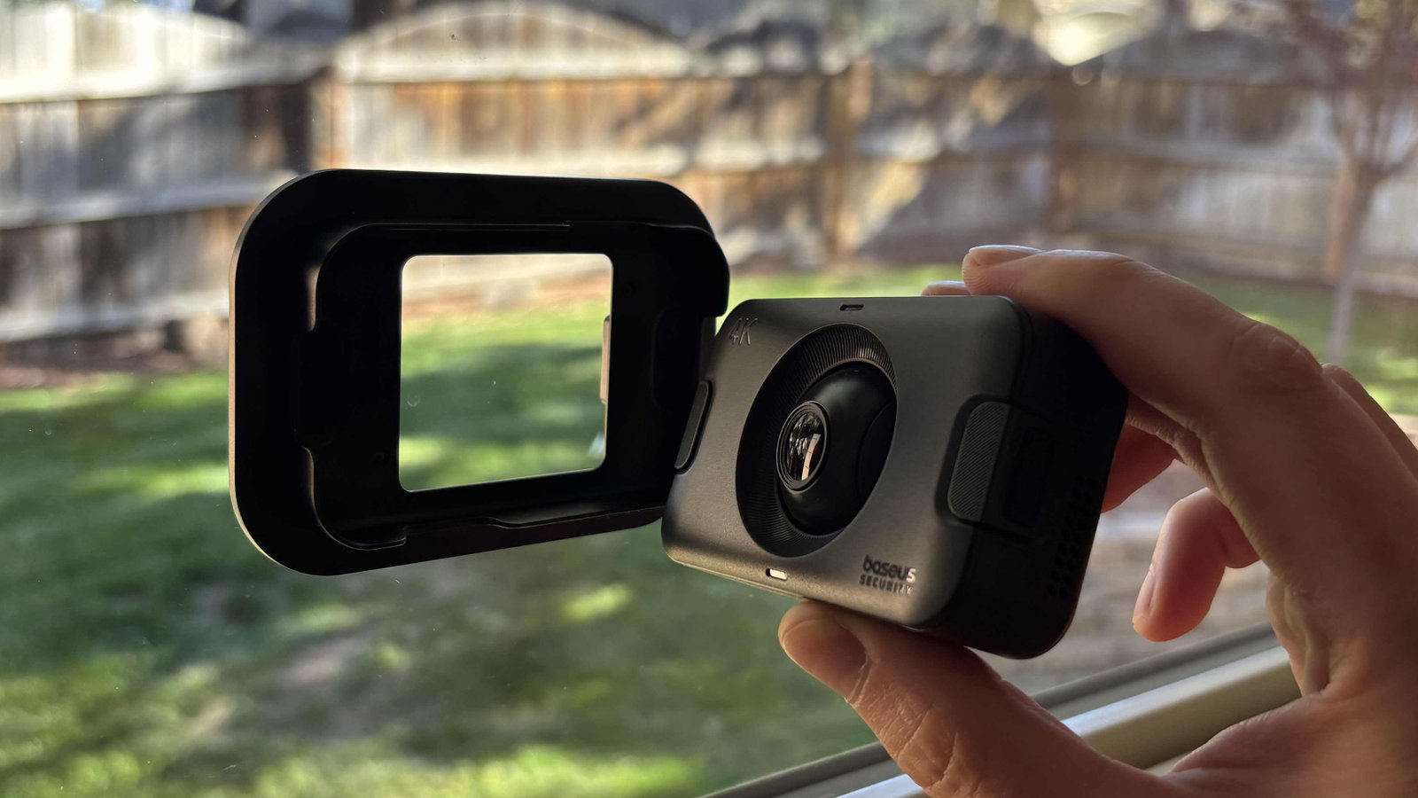 A hand holds the Baseus window cam next to its frame.